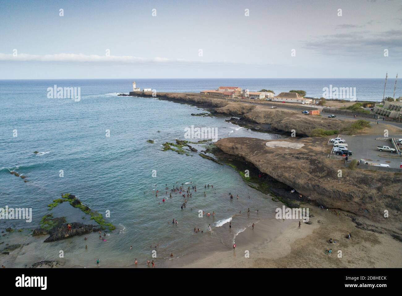 Strandgänger spielen im Wasser in der Nähe des Praia Leuchtturms in Santiago, Cabo Verde. Stockfoto