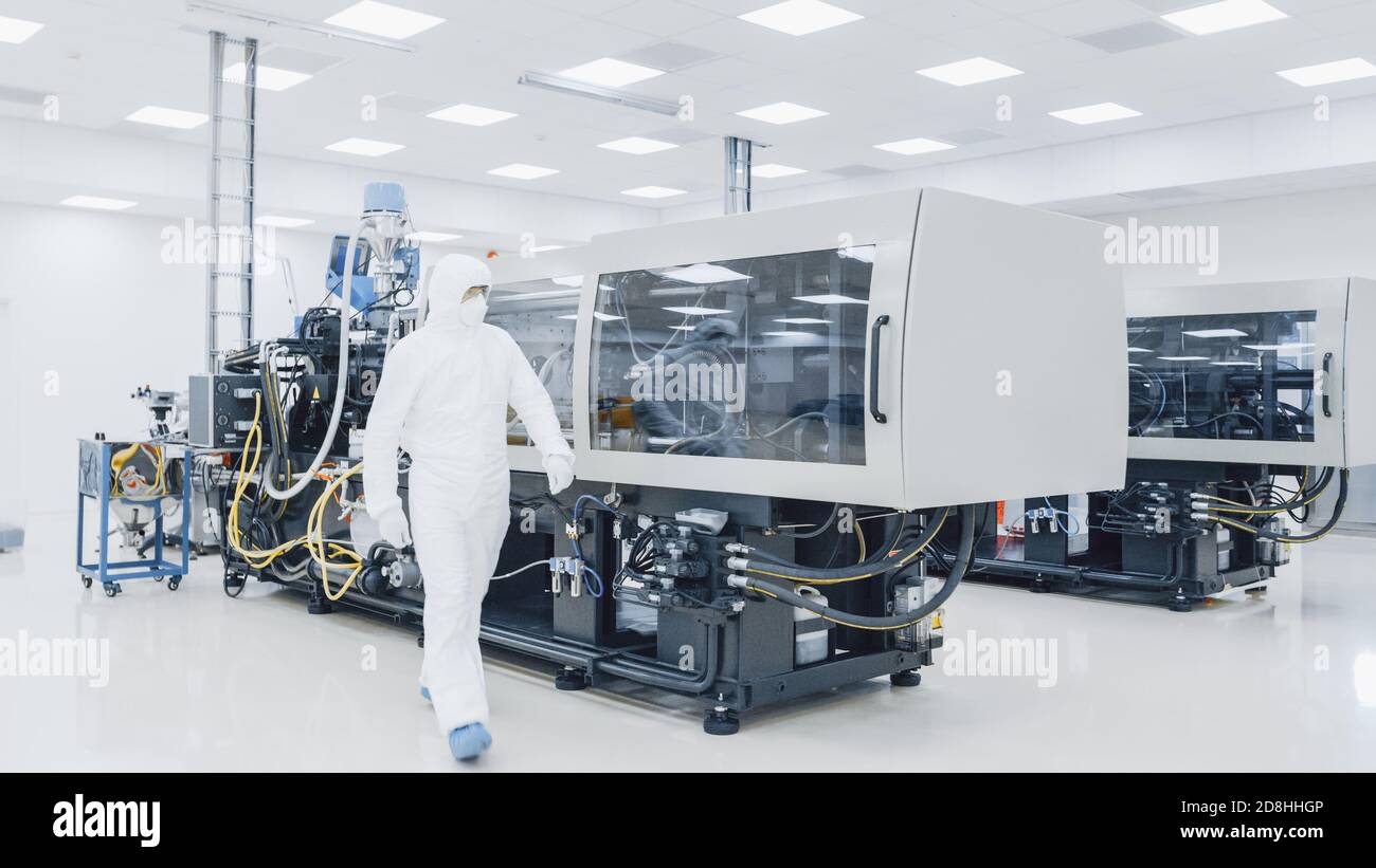 Auf einem Fabrikwissenschaftler in steriler Schutzkleidung Arbeiten an einer modernen industriellen 3D-Druckmaschine. Pharmazeutische, biotechnologische und Stockfoto