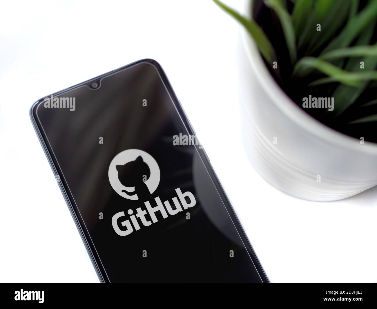 LOD, Israel - 8. Juli 2020: Moderner minimalistischer Büroarbeitsplatz mit schwarzem Smartphone mit GitHub App Launch Screen mit Logo auf weißem Backgroun Stockfoto