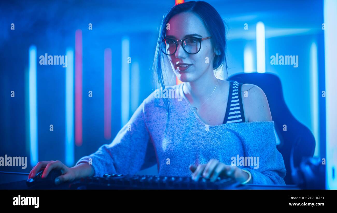 Schöne professionelle Gamer Mädchen spielen und Streaming Online-Video-Spiel auf ihrem persönlichen Computer. Casual Cute Geek trägt eine Brille. Cyber e-Sport Stockfoto