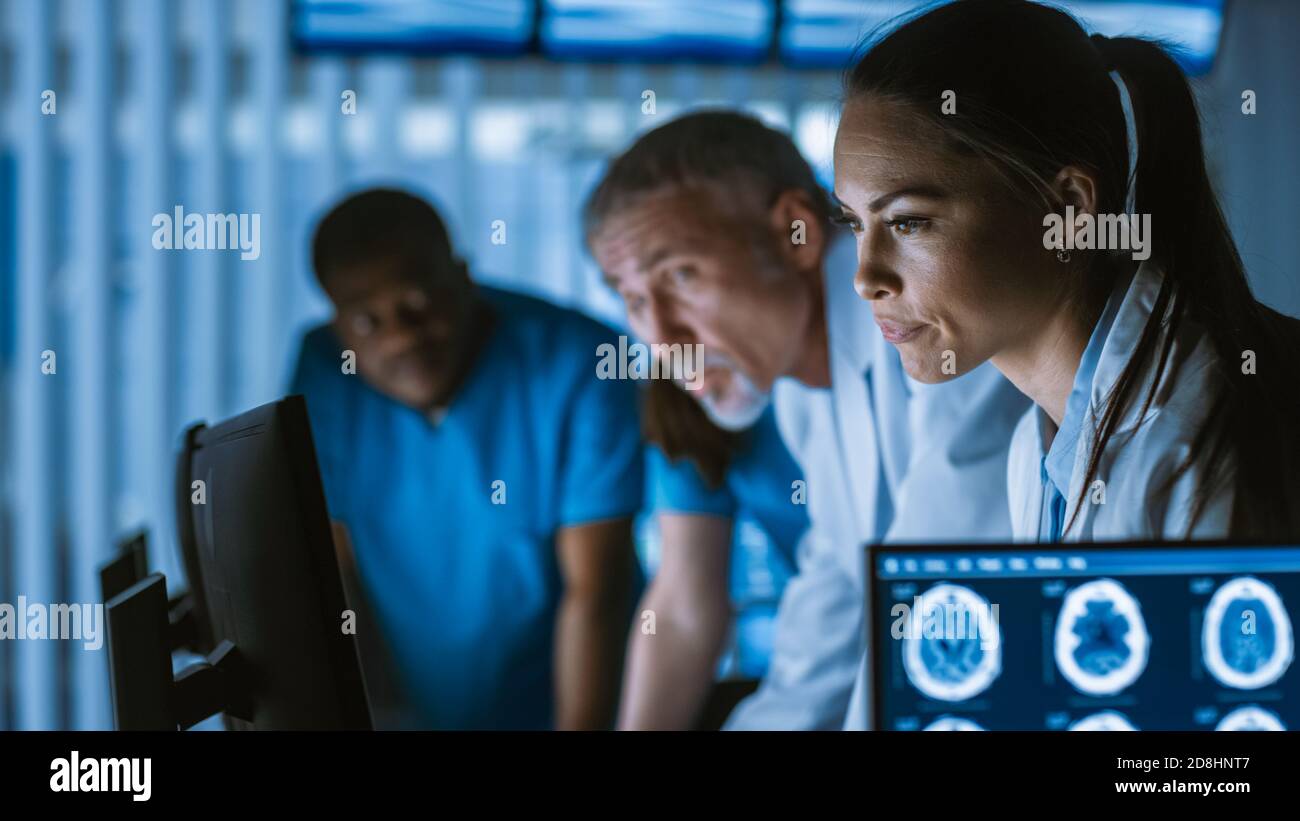 Diverse Gruppe von Medizinern lösen Probleme und zeigen auf Computer-Bildschirme zeigt CT, MRT-Scans. Neurologen Neurowissenschaftler arbeiten im Gehirn Stockfoto