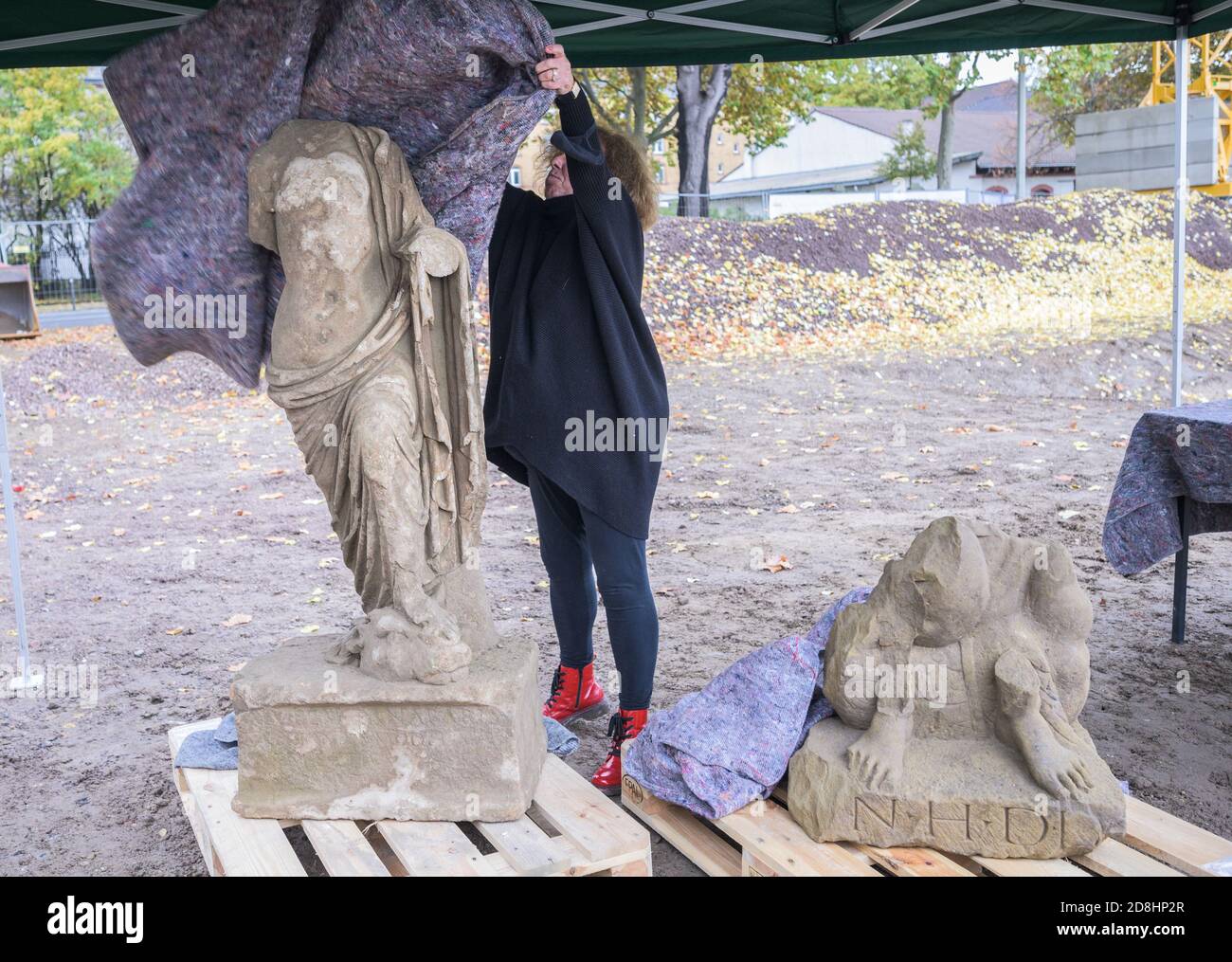 30. Oktober 2020, Rheinland-Pfalz, Mainz: Marion Witteyer, Leiterin der Mainzer Zweigstelle der Landesarchäologie der Generaldirektion Kulturerbe Rheinland-Pfalz in Mainz, enthüllt eine römische Skulptur am Zollhafen. Nach heutigem Kenntnisstand ist die freistehende Skulptur um 150 n. Chr. datiert und soll eine weibliche Gottheit darstellen. Das Skulpturfragment (r, ca. 150 n. Chr.) soll einen Mann mit einem schlangenförmigen Wesen darstellen. Bisher wurden bei Ausgrabungen im Custo zwei Skulpturen, keramische Scherben, Siedlungsreste und verschiedene Funde gefunden Stockfoto