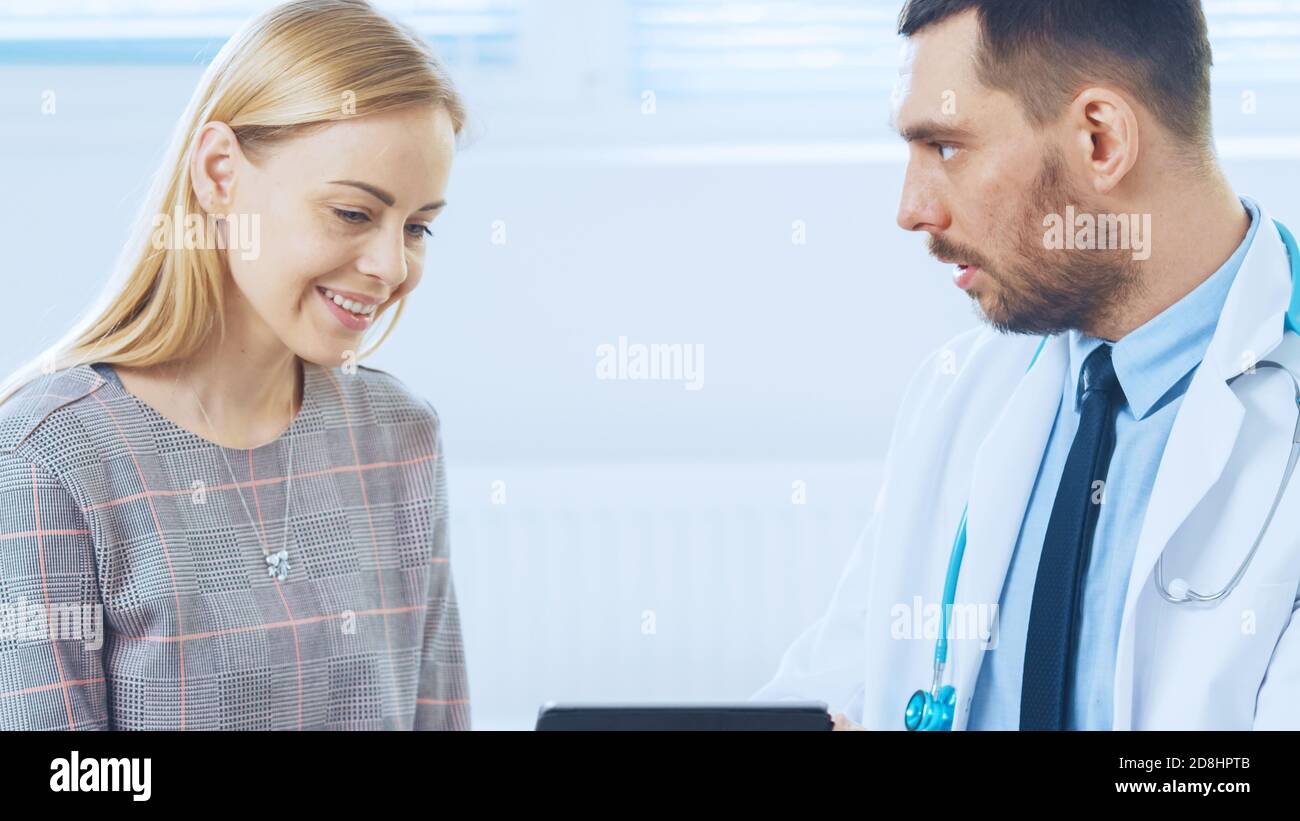 Schöne Frau besucht Arztpraxis, Er zeigt Tablet-Computer mit ihrer medizinischen Geschichte diskutieren sie ihre Gesundheit und andere medizinische Fragen. Modern Stockfoto