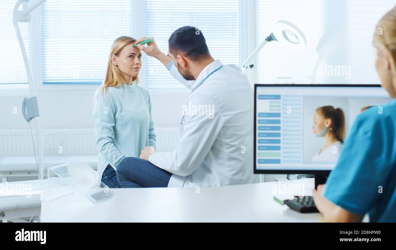 Plastischer Schönheitschirurg mit weiblicher Patientin, Er zeichnet Linien auf ihrem Gesicht für zukünftige Facelift-Operation. Pflegepersonal plant das Facelift des Computerpatienten Stockfoto