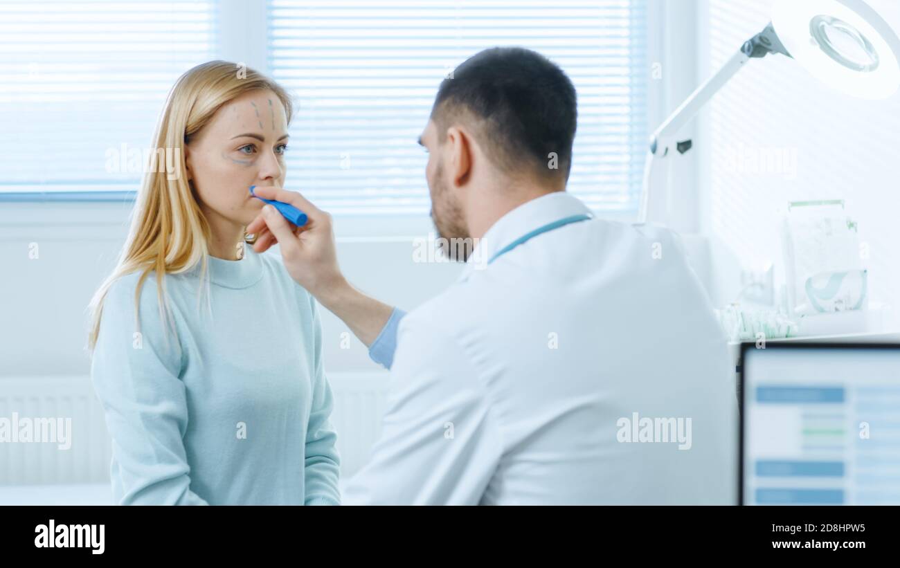 Plastischer Schönheitschirurg mit weiblicher Patientin, Er zeichnet Linien auf ihrem Gesicht für zukünftige Facelift-Operation. Pflegepersonal plant das Facelift des Computerpatienten Stockfoto