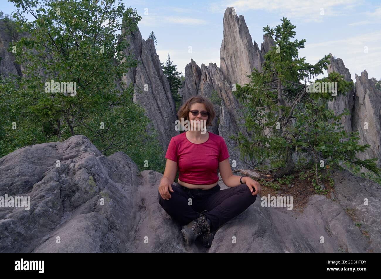 Fröhliche Frau Tourist sitzt auf dem Dach des Felsens Stockfoto