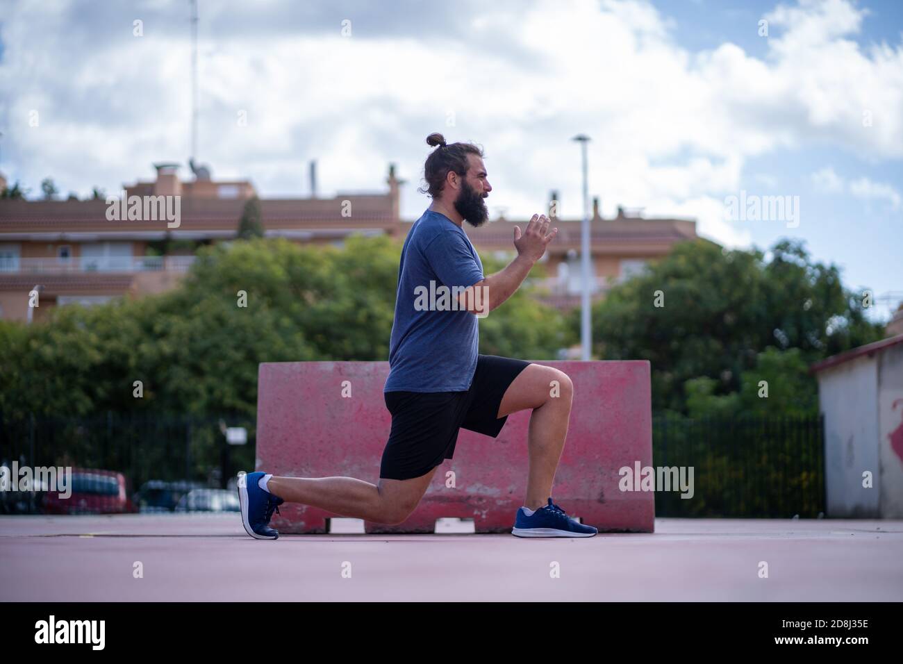 Mann trainiert seine Beine mit Power Ausfallschritte in einem Park Im Freien Stockfoto