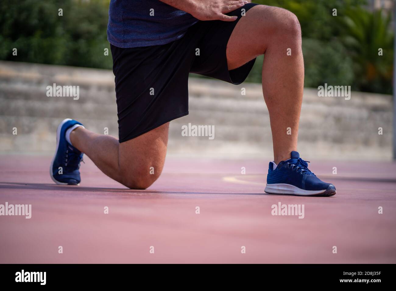 Detail eines Mannes, der seine Beine mit Power Ausfallschritte trainiert In einem Park im Freien Stockfoto