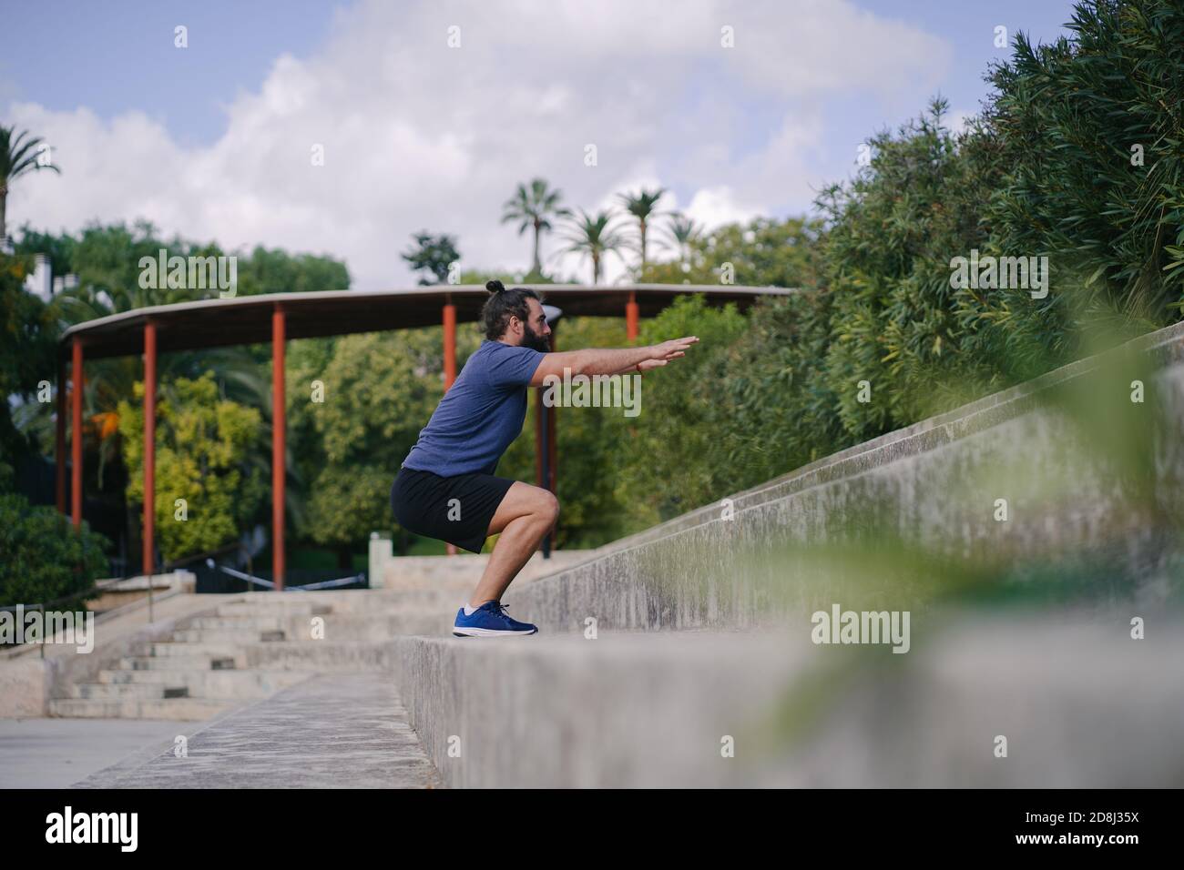Mann trainiert mit hockigen Sprüngen auf den Stufen eines Fußballplatz Stockfoto