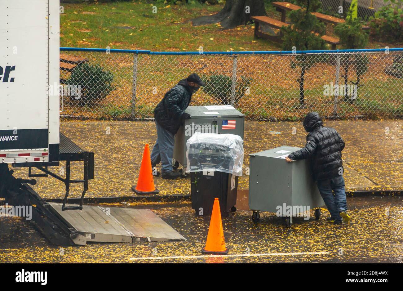 Arbeiter des New Yorker Wahlvorstands liefern Scanner und andere Geräte an einem nassen Donnerstag, den 29. Oktober 2020, vor den Wahlen am 3. November an das Wahllokal PS33 in Chelsea in New York. (© Richard B. Levine) Stockfoto