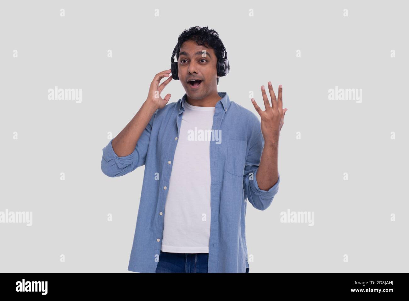 Indischer Mann, der Musik vom Telefonsingen zu ihm hört. Mann, der zur Musik singt. Mann überrascht von Musik Stockfoto