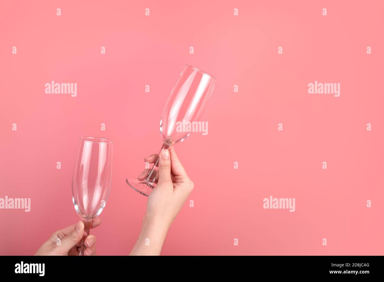 Weingläser auf einem rosa Hintergrund in den Händen einer Frau. Stockfoto