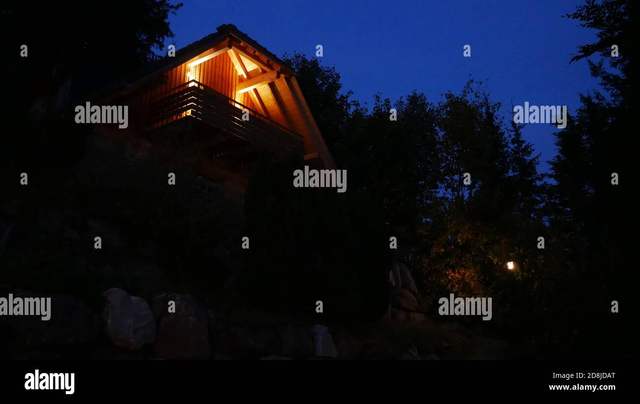 Beleuchtetes Holzhaus im Schwarzwald bei Nacht Stockfoto