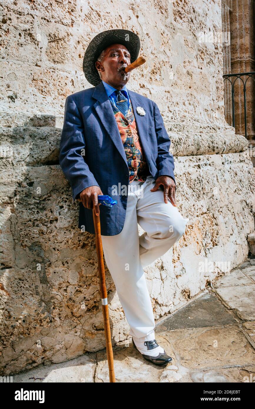 Ein makellos gekleideter kubanischer Herr, der auf den Straßen von Havanna Zigarre raucht. La Habana - La Havanna, Kuba, Lateinamerika und die Karibik Stockfoto