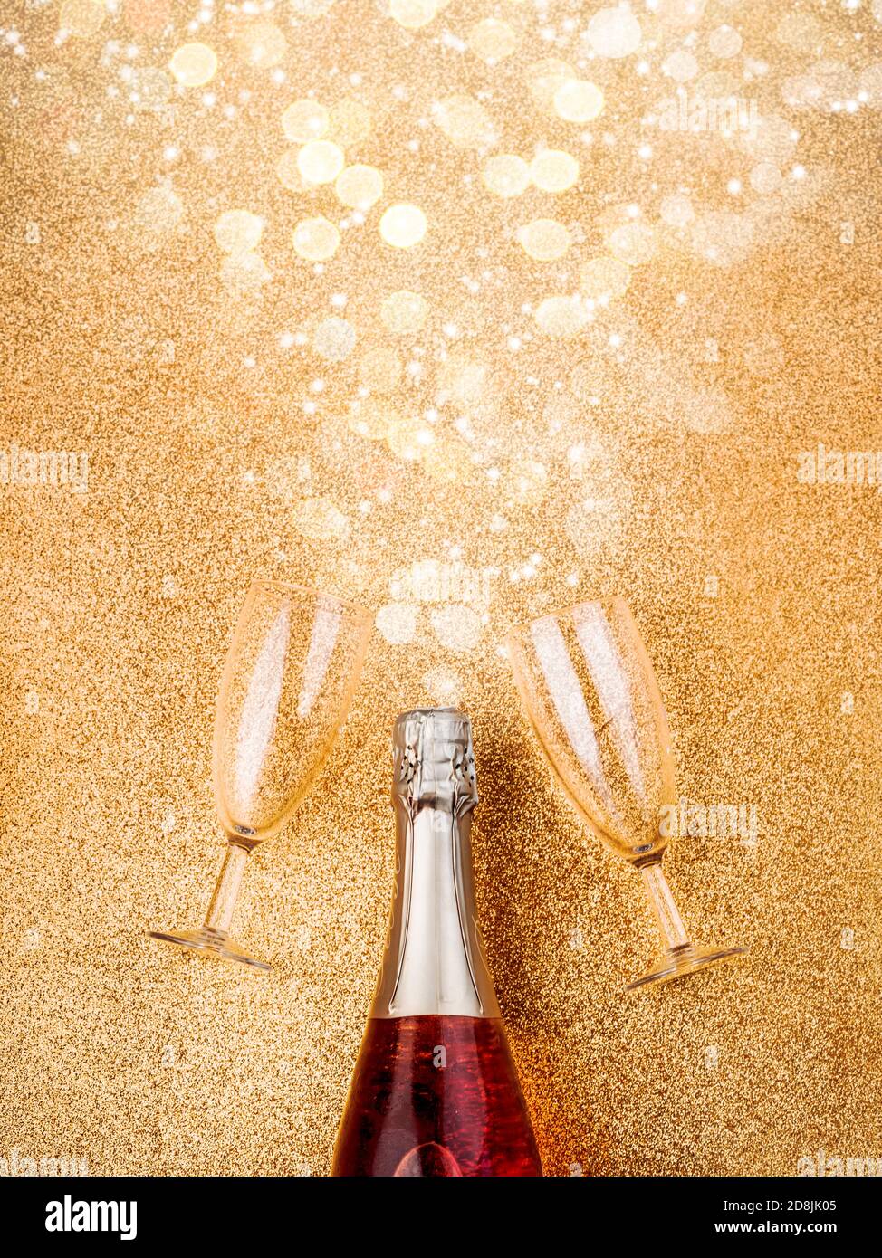 Frohes neues Jahr. Silvester Feier Konzept Hintergrund.Champagner-Flasche mit zwei Gläsern auf goldenem Hintergrund Stockfoto
