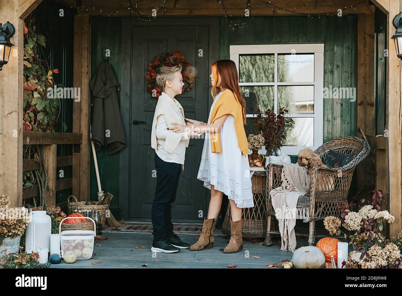 Kinder ein Junge und ein Mädchen mit Spaß auf der Veranda des Hinterhofs mit Kürbissen im Herbst dekoriert Stockfoto