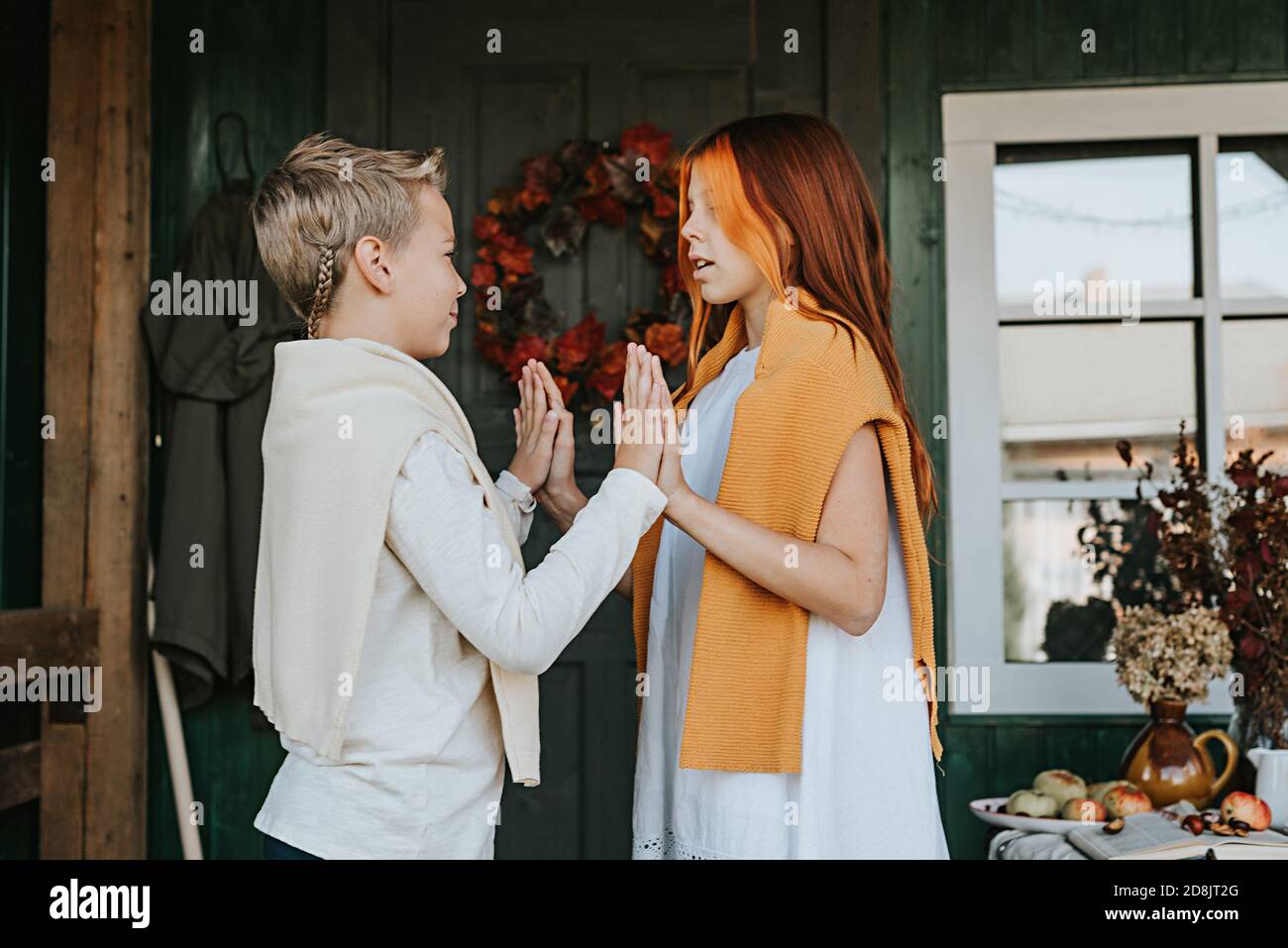 Kinder ein Junge und ein Mädchen mit Spaß auf der Veranda des Hinterhofs mit Kürbissen im Herbst dekoriert Stockfoto