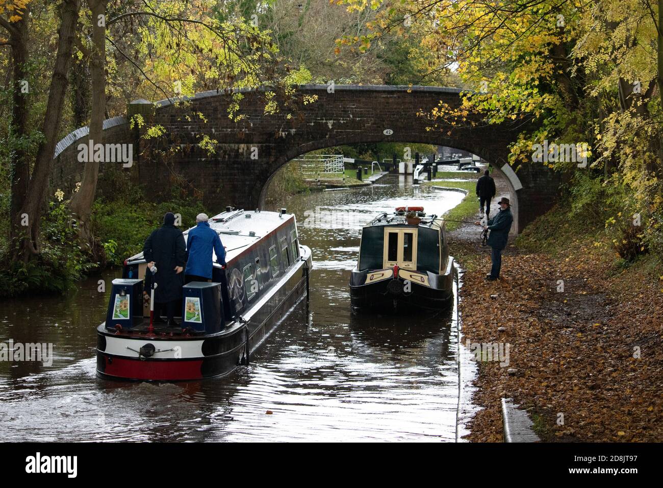 Kanalboote auf dem Coventry Kanal in Atherstone, North Warwickshire. Im Oktober 2020 wurde die Schleuse Nummer zwei auf dem Atherstone-Schleusenflug gebrochen, was dazu führte, dass Boote hochgehalten wurden, wodurch eine Schlange von Booten entstand, die darauf warteten, entlang der Wasserstraße voranzukommen. Stockfoto