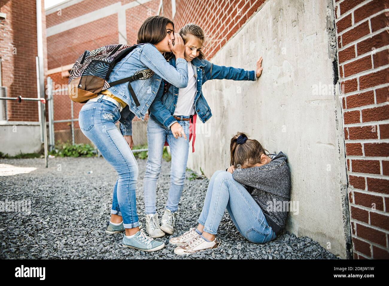 Ein trauriges Mädchen Einschüchterung Moment auf der elementaren Alter Mobbing Auf dem Schulhof Stockfoto