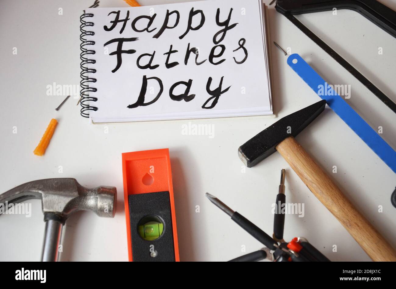 Happy Father's Day Inschrift mit Arbeitswerkzeugen auf weißem Hintergrund. Grüße und Geschenke Stockfoto