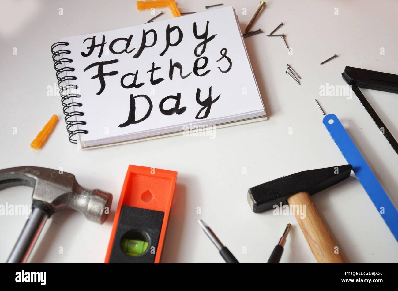 Happy Father's Day Inschrift mit Arbeitswerkzeugen auf weißem Hintergrund. Grüße und Geschenke Stockfoto