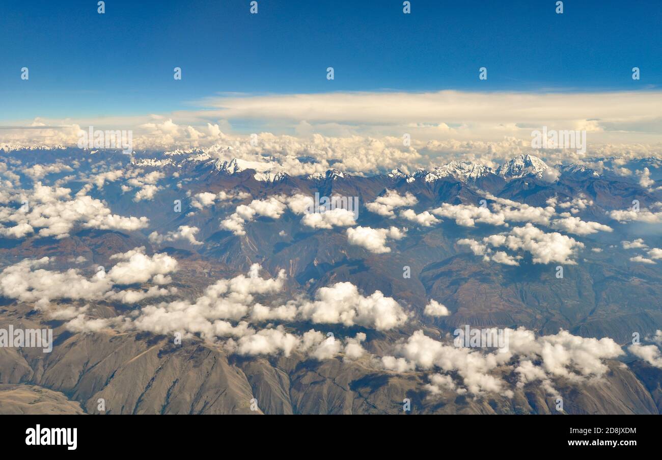 Luftaufnahme des Andenmassivs über Peru, mit verstreuten weißen Wolken darüber Stockfoto