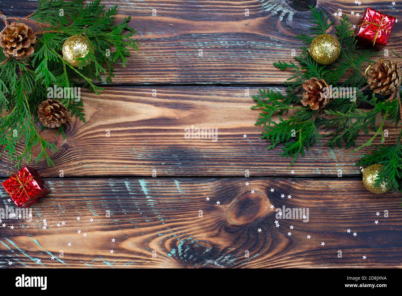 Weihnachtskomposition Spielzeug, Geschenke und Zweige eines Weihnachtsbaumrahmens auf Holzhintergrund Stockfoto