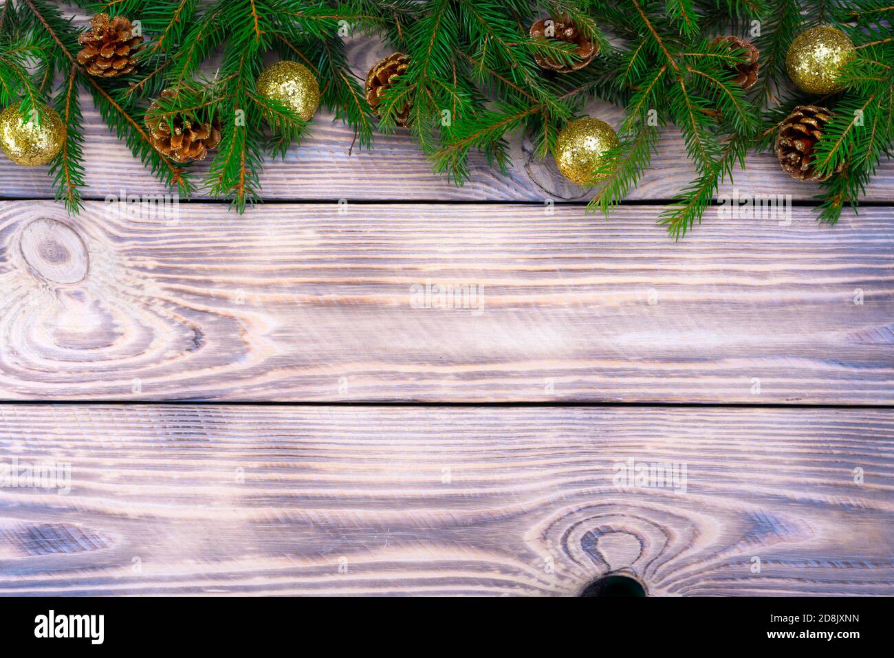 Weihnachtskomposition Spielzeug, Geschenke und Zweige eines Weihnachtsbaumrahmens auf Holzhintergrund Stockfoto
