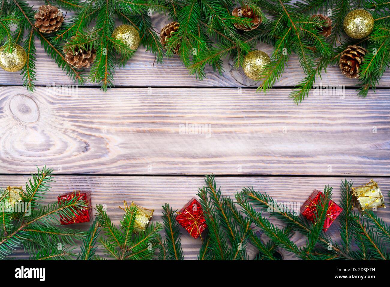 Weihnachtskomposition Spielzeug, Geschenke und Zweige eines Weihnachtsbaumrahmens auf Holzhintergrund Stockfoto