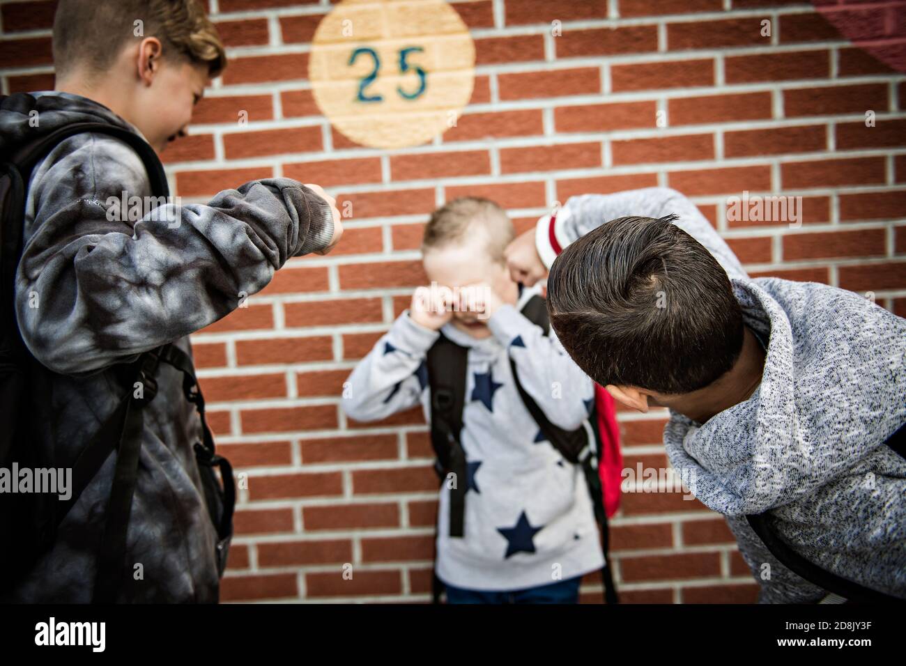 Traurige Einschüchterung Moment Grundalter Mobbing in Schulhof Stockfoto