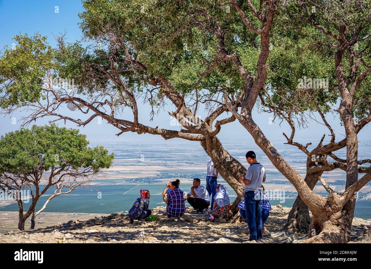 Familie, die nach dem Klettern im Schatten eines Baumes ruht Auf einem Berg auf einer Pilgerfahrt Stockfoto