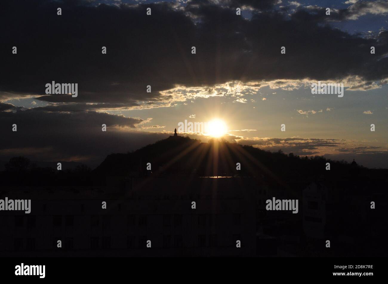 Sonnenuntergang hinter einem Berg in Plovdiv Bulgarien - mit Wolken Und einen Turm Stockfoto