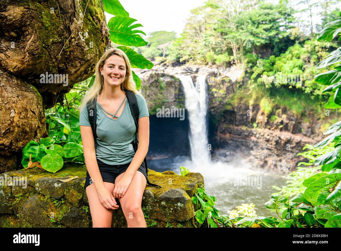 Eine Frau an den Rainbow Falls, Hilo, Wailuku River State Park, Big Island, Hawaii Stockfoto