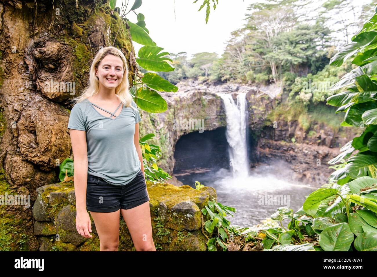 Eine Frau an den Rainbow Falls, Hilo, Wailuku River State Park, Big Island, Hawaii Stockfoto