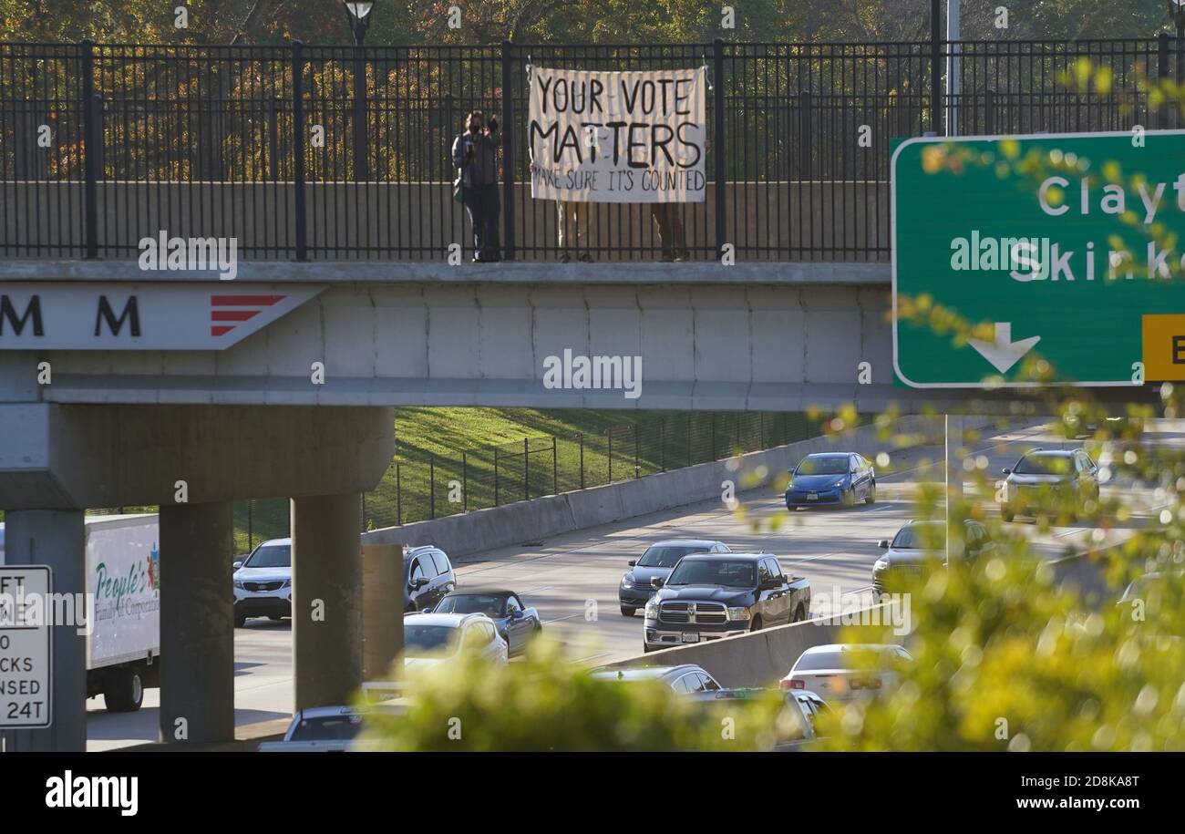 St. Louis, Usa. Oktober 2020. Eine Gruppe von drei Personen steht in der Nähe ihres Banners auf der Überführung der Tamm Avenue über Highway 64, in St. Louis am Freitag, 30. Oktober 2020. Das Banner mit der Aufschrift "Your Vote Matters" wurde zur Hauptverkehrszeit auf die Brücke gesetzt, um die Fahrer daran zu erinnern, am 3. November abzustimmen. Foto von Bill Greenblatt/UPI Kredit: UPI/Alamy Live News Stockfoto