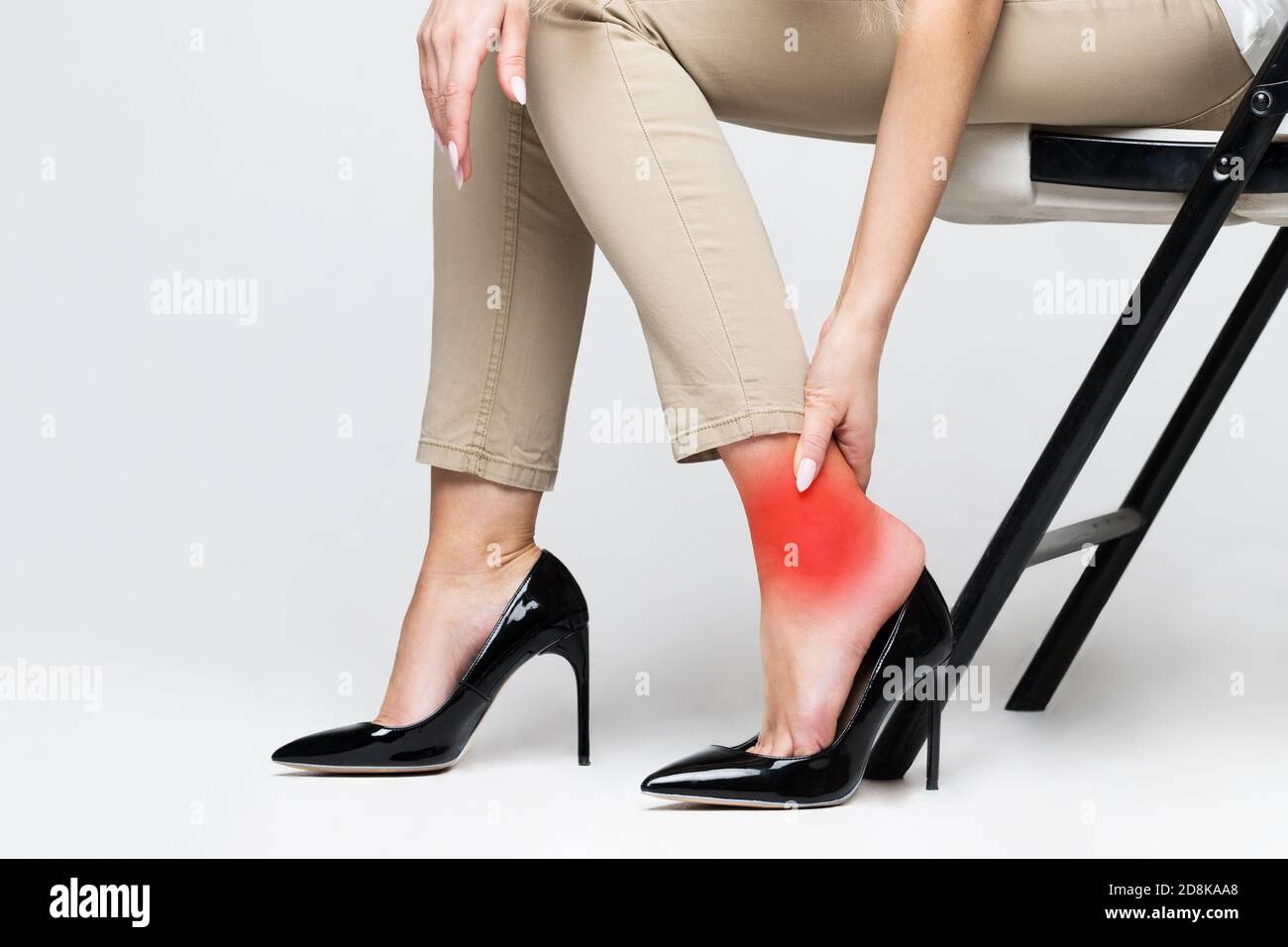 Müde Frau berührt ihren Knöchel, leiden unter Beinschmerzen wegen unbequemen Schuhen, Füße Schmerzen tragen hohe Ferse Schuhe. Syndrom der Büroarbeit. Anschwellen Stockfoto