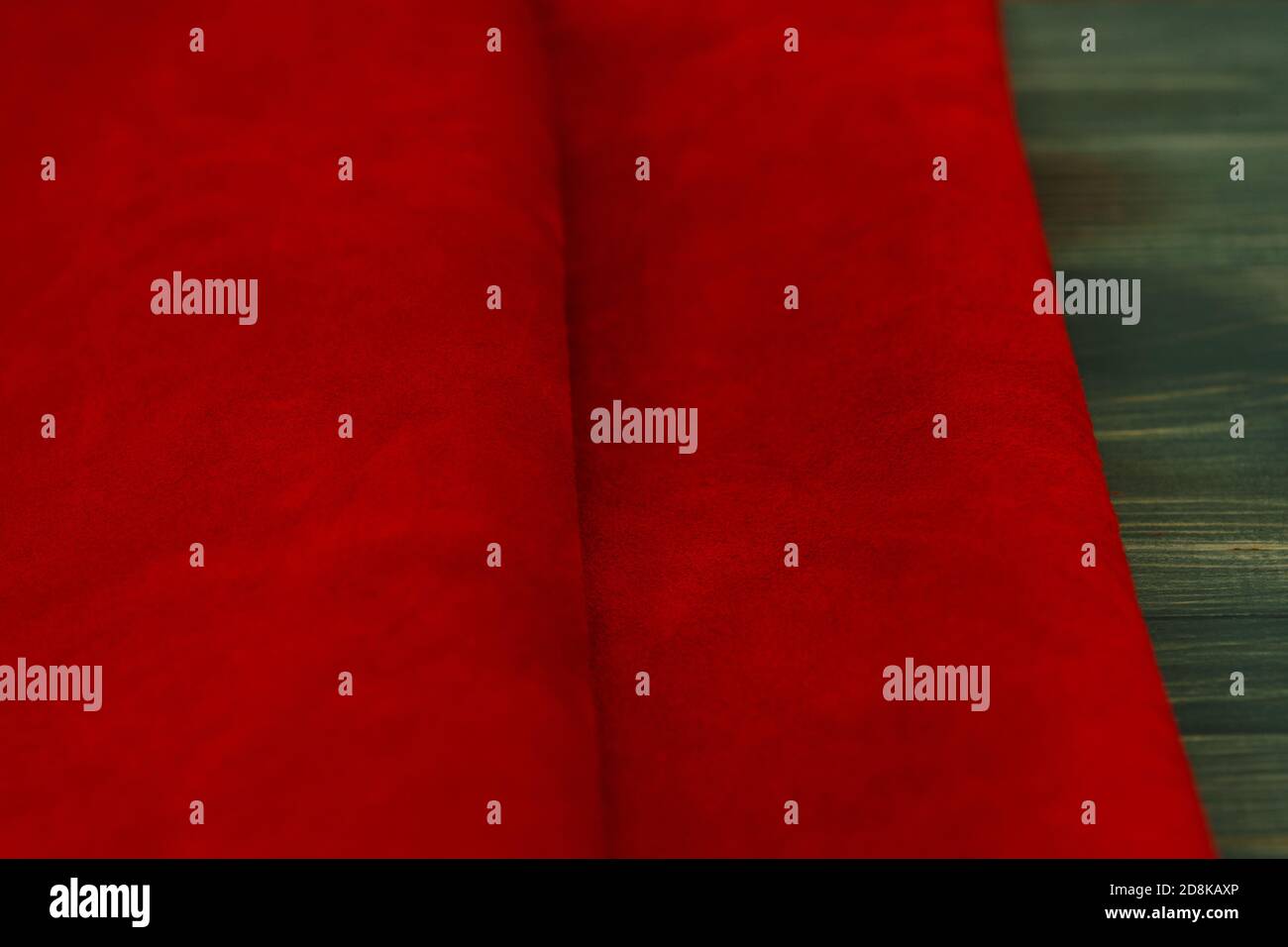 Rot matt Hintergrund aus Wildleder Stoff, Nahaufnahme. Samtstruktur aus nahtlosem Leder. Makro Filzmaterial. Stockfoto