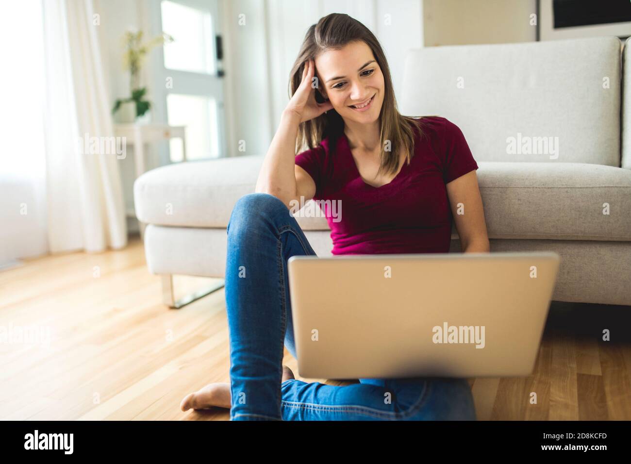 Brunette mit gute Zeit auf dem Wohnzimmer mit Laptop Stockfoto