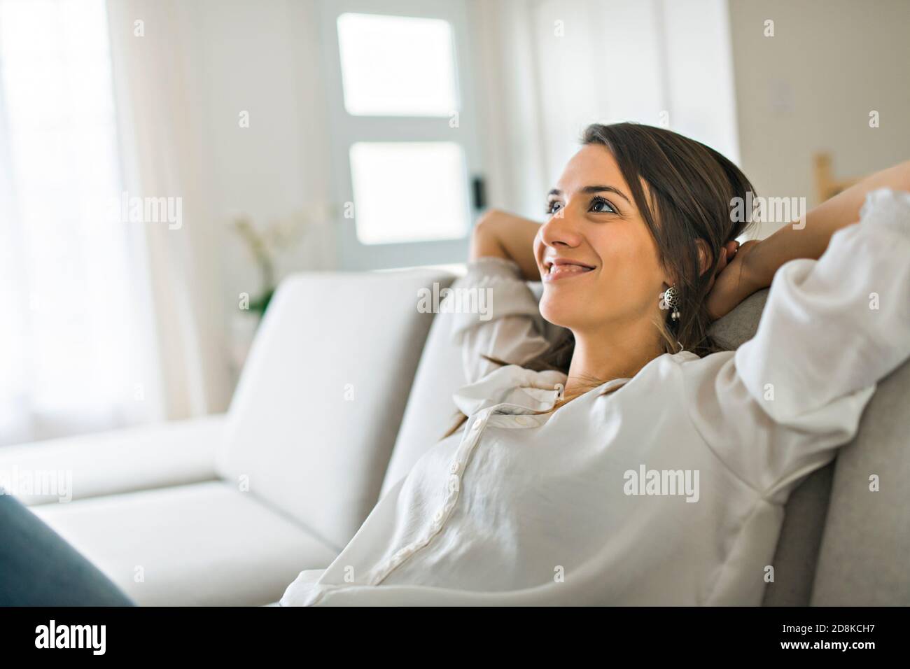 Entspannen Sie Brünette mit gute Zeit auf dem Wohnzimmer Stockfoto