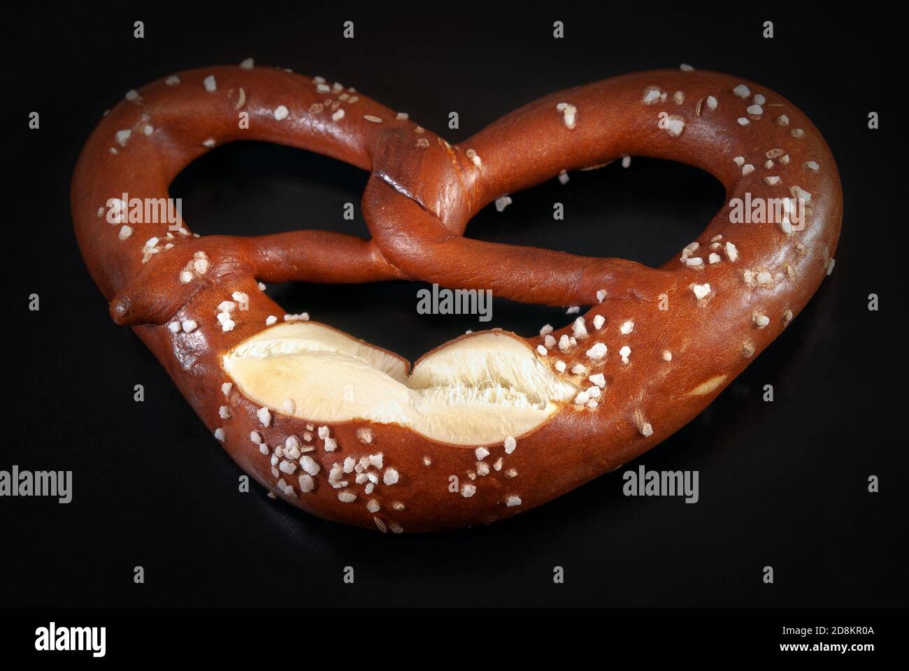 Brezel mit Salz auf schwarzem Grund. Nahaufnahme des Bildes Stockfoto