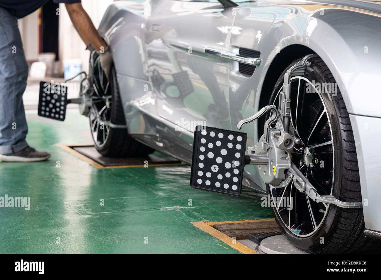 Arbeiter, der die Ausrüstung der Radausrichtvorrichtung an den Radwagen anfügt Stockfoto