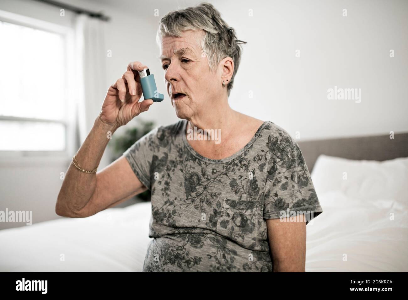 Alte ältere Frau verwenden Inhalator Medizin alte Asthma-Patienten in Schlafzimmer Stockfoto