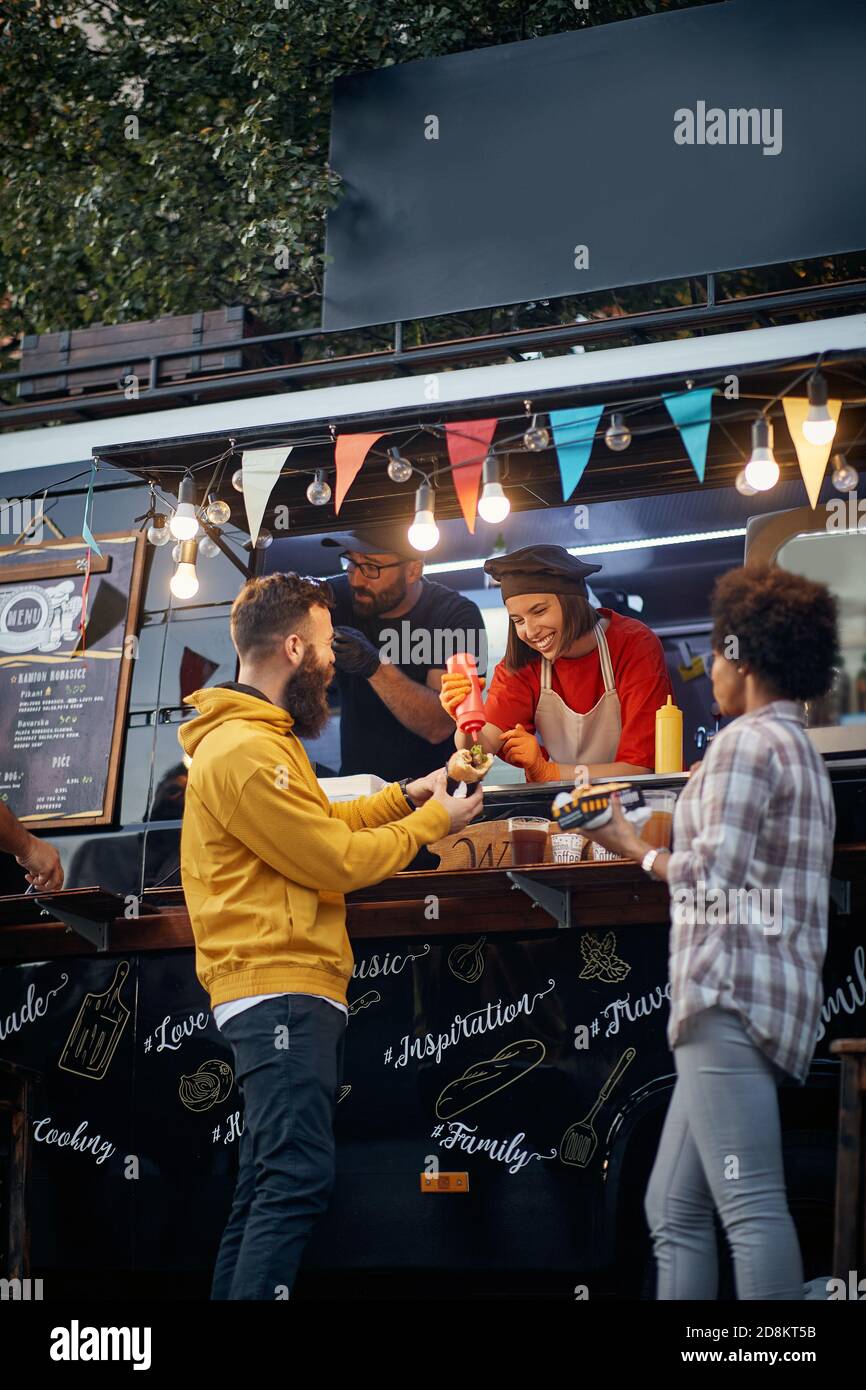 Gruppe von Freunden, die Spaß an Fast-Food-Mobile-Service Stockfoto