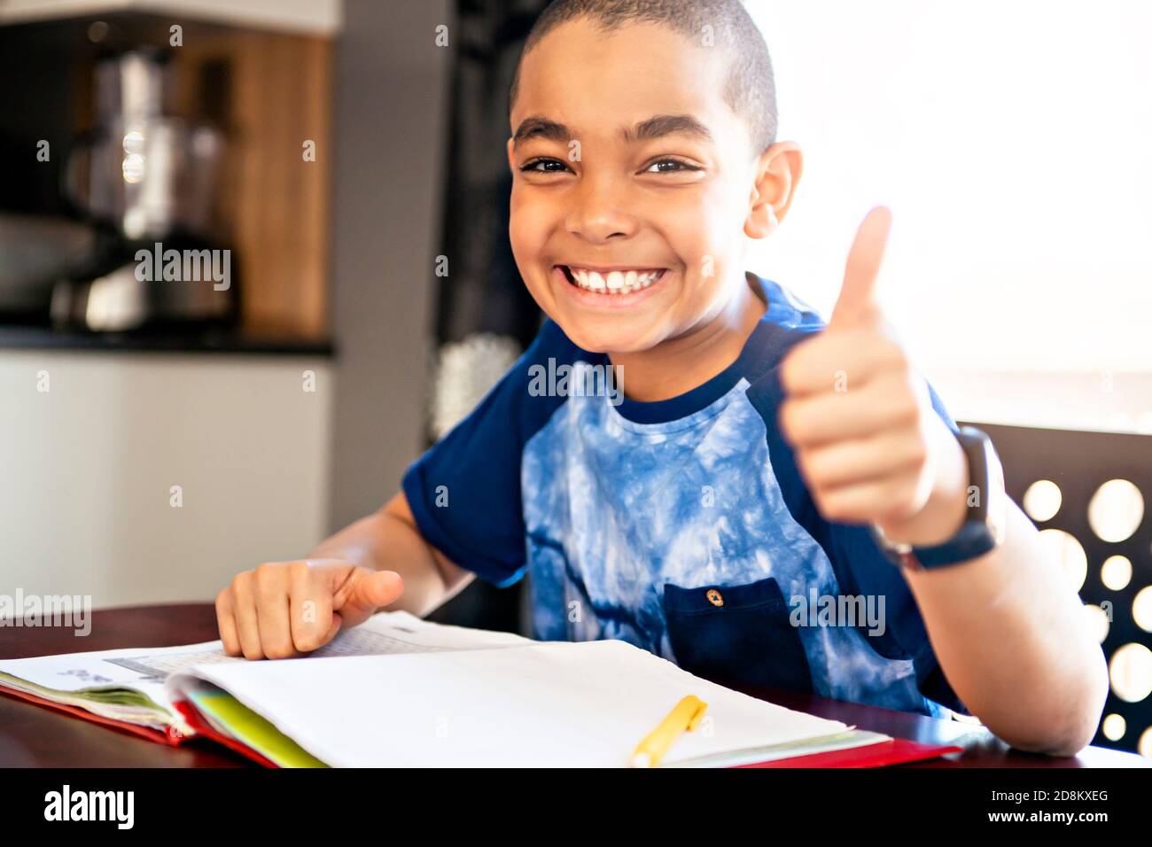 Ein männliches schwarzes Kind macht Hausaufgaben zu Hause Stockfoto
