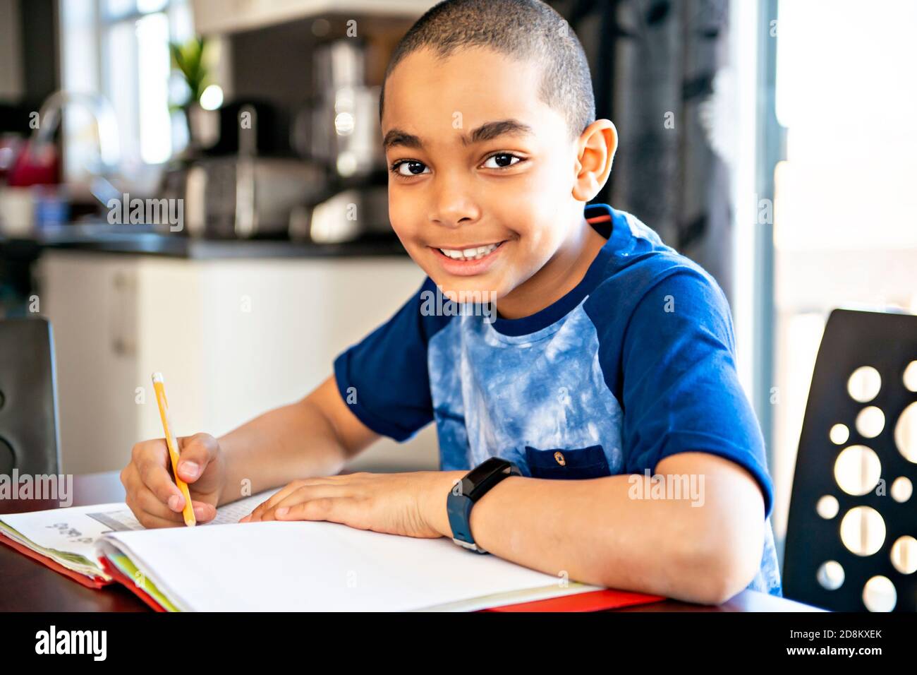 Ein männliches schwarzes Kind macht Hausaufgaben zu Hause Stockfoto