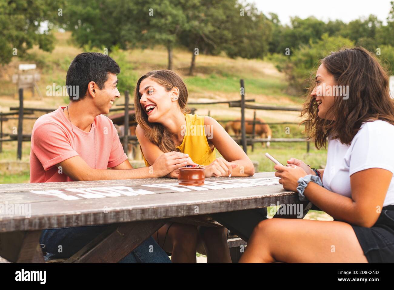 Freunde, die Spaß haben und draußen auf einer Ranch mit Pferden und Pony lachen. Ranch Konzept Fotografie Stockfoto