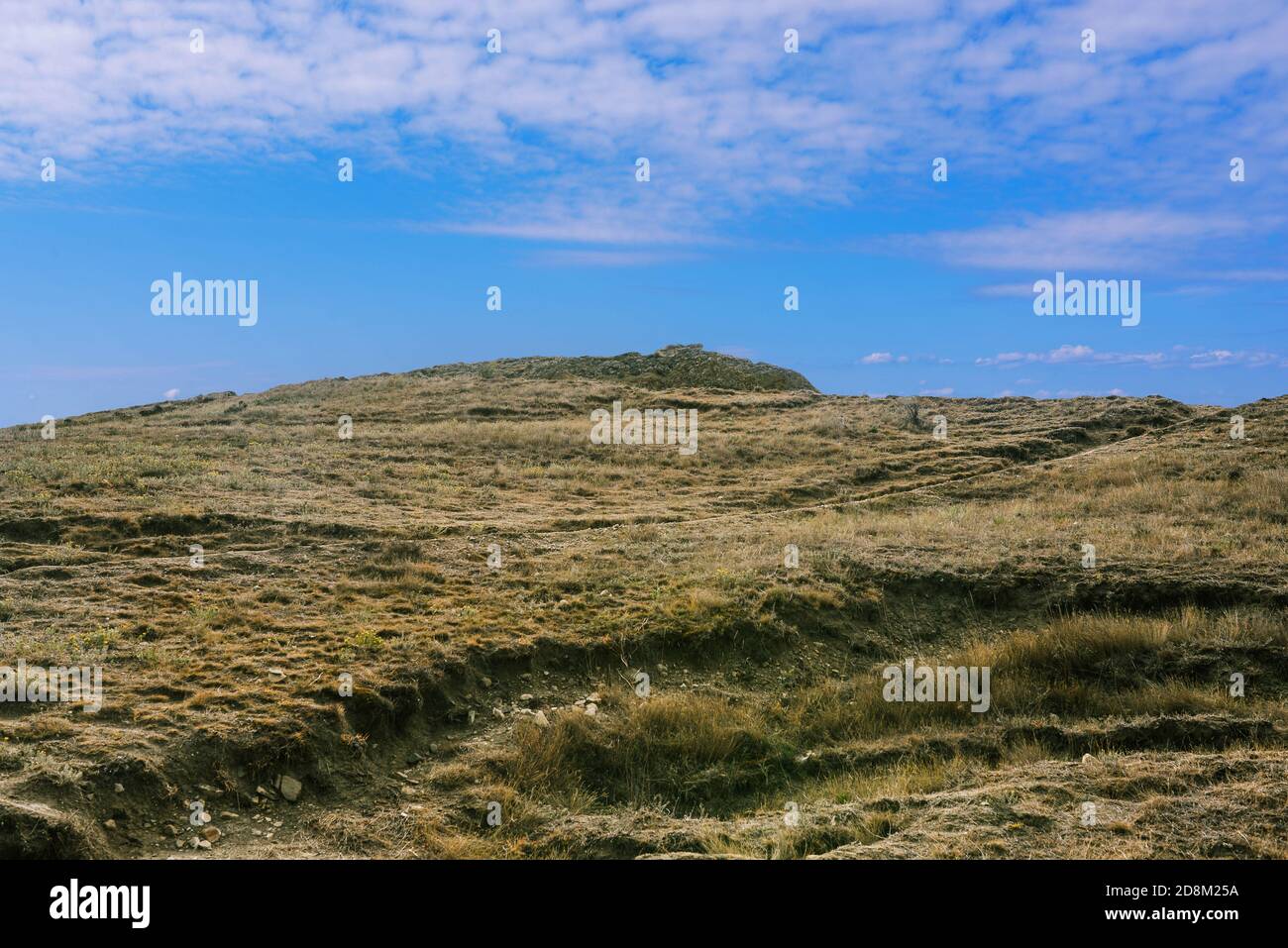 Hügeliges Gelände und blauer Himmel. Berggipfel und Wanderweg. Klettern und Reisen in die Berge. Aktiver Tourismus Stockfoto