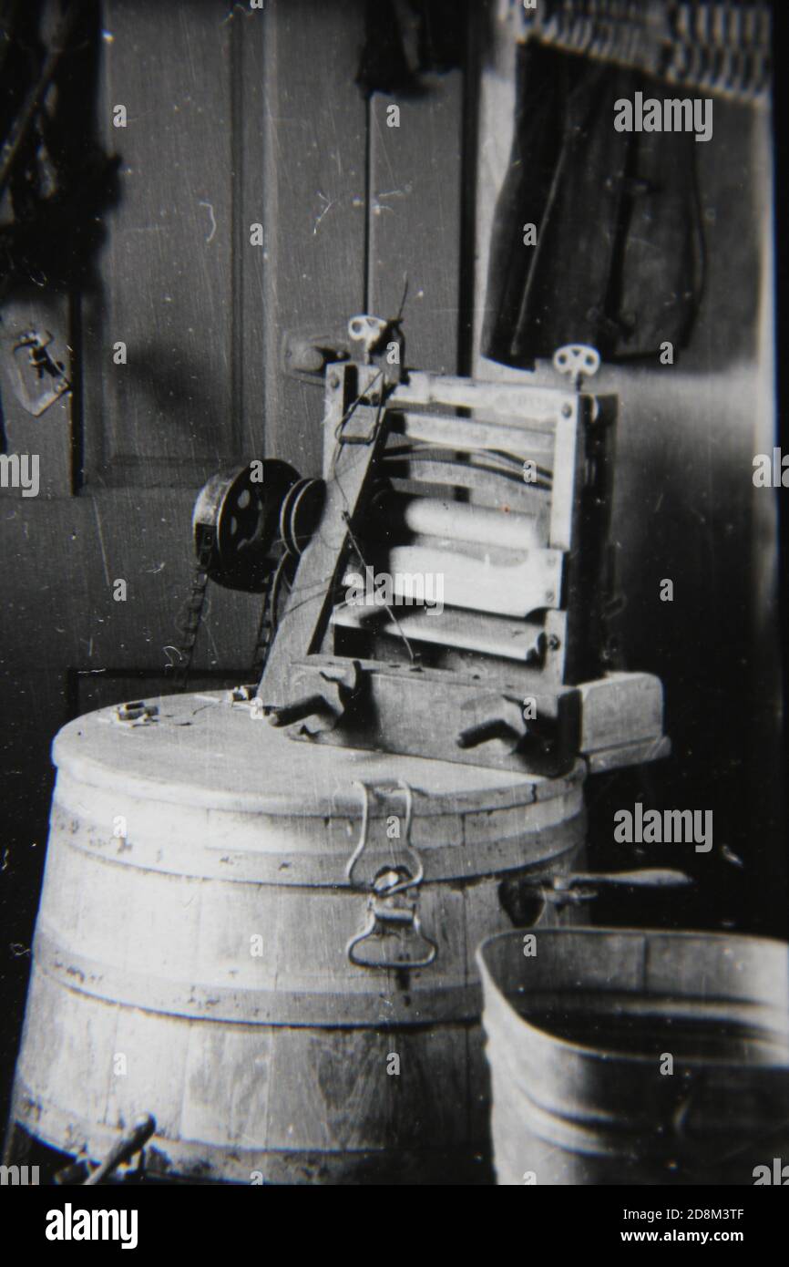 Feine Schwarz-Weiß-Vintage-Fotografie einer Handwaschmaschine aus den 1970er Jahren in einem Landhaus in den USA. Stockfoto