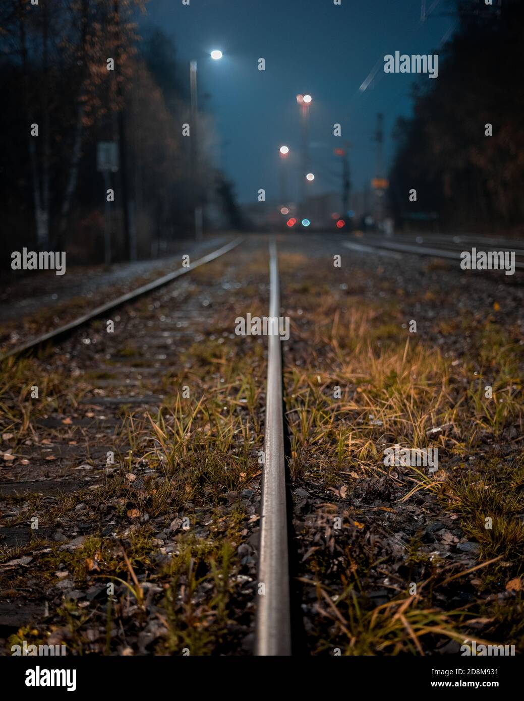 Moody Blick auf eine Eisenbahn in der Nacht. Selektiver Fokus auf den Vordergrund. Stockfoto