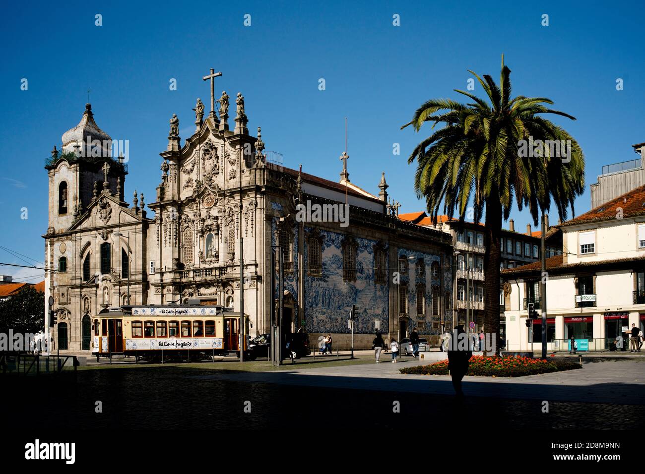 Blick auf Porto, Portugal, mit einer Kirche mit Azulejos, Vintage-Straßenbahn und einer Palme Stockfoto